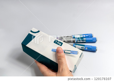Hands holding Ozempic Insulin injection pen for diabetics and weight loss. Medical equipment for diabetes parients. Hands holding Ozempic Insulin injection pen for diabetics and weight loss. Medical equipment for diabetes parients. 120178107