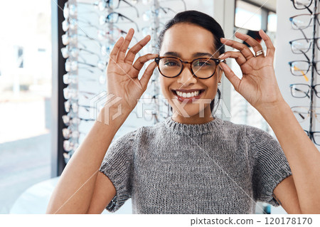 The best eyewear brands in the optometry business. Shot of a young woman buying a new pair of glasses at an optometrist store. The best eyewear brands in the optometry business. Shot of a young woman buying a new pair of glasses at an optometrist store. 120178170