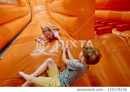 Friends having fun on leather slide 120178236