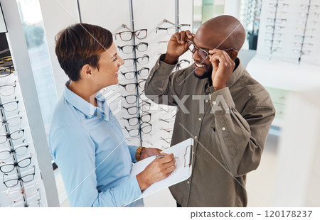 They fit perfectly. Shot of a an optometrist helping a young man choose a new pair of glasses. 120178237