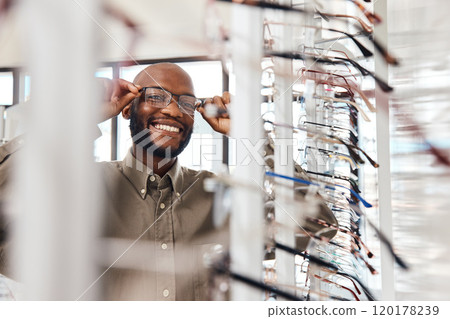 The perfect pair for me. Shot of a young man buying a new pair of glasses at an optometrist store. The perfect pair for me. Shot of a young man buying a new pair of glasses at an optometrist store. 120178239