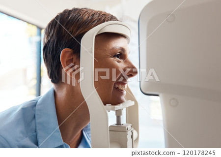 See your best with an annual eye test. Shot of a young woman getting her eyes examined with an autorefractor. 120178245