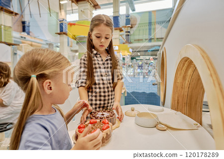 Girls playing chef on playground kitchen 120178289