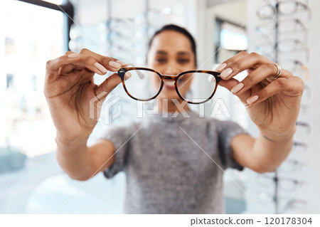 Youve got to see it to believe it. Shot of a young woman buying a new pair of glasses at an optometrist store. 120178304