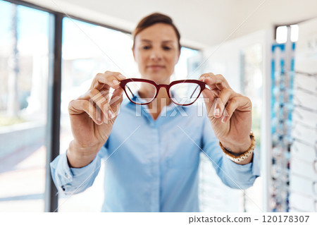 As glare free as it gets. Shot of a young woman buying a new pair of glasses at an optometrist store. 120178307