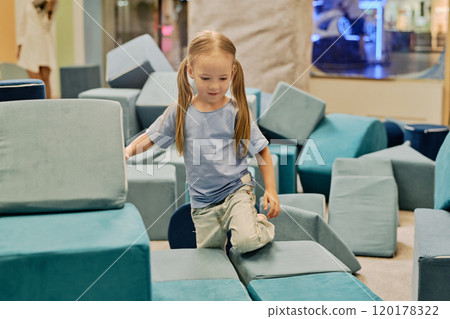 Girl playing with big soft toy cubes Girl playing with big soft toy cubes 120178322