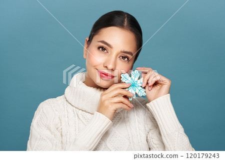 Woman in a white knitted sweater with cookie Snowflake 120179243