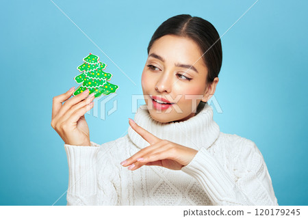 Woman in a white knitted sweater with cookie Christmas tree Woman in a white knitted sweater with cookie Christmas tree 120179245
