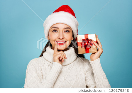 Beautiful woman in a white knitted sweater with gift box 120179248
