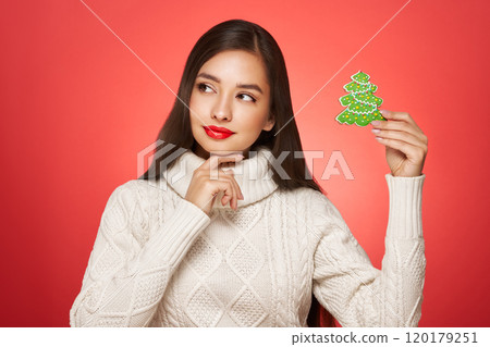 Beautiful woman in a white knitted sweater with gift box 120179251