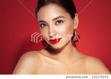Portrait of beautiful young woman on red background 120179259