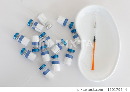 Vials and syringe on white table. Vaccination and immunization for people 120179344
