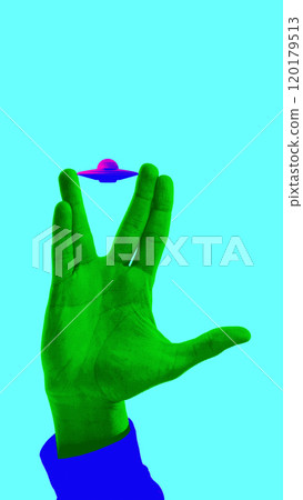 Green hand making Vulcan salute, with a miniature UFO floating above it against turquoise background. Contemporary art collage. 120179513