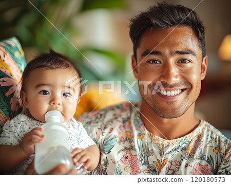 father smiles while feeding his infant bottle their lively living room. space filled tropical plants and colorful cushions creating joyful atmosphere. 120180573