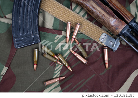 AK assault rifle on camo uniform background AK assault rifle on camo uniform background 120181195