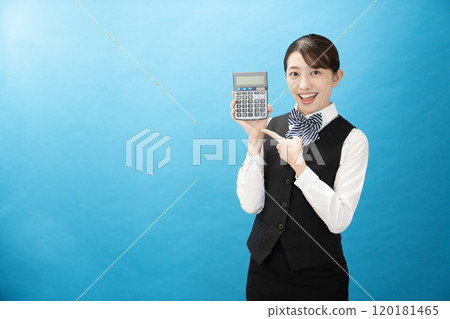 Business woman with a blue back and a smile holding a calculator Business woman with a blue back and a smile holding a calculator 120181465