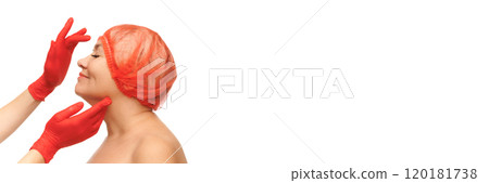Banner. Side profile of mature woman in red hair cap smiling as hands in red gloves touch her face and chin against white studio background. Banner. Side profile of mature woman in red hair cap smiling as hands in red gloves touch her face and chin against white studio background. 120181738