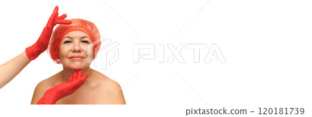 Banner. Woman in red hair cap with closed eyes gently touched on her face and chin by hands wearing red gloves against white studio background. Banner. Woman in red hair cap with closed eyes gently touched on her face and chin by hands wearing red gloves against white studio background. 120181739