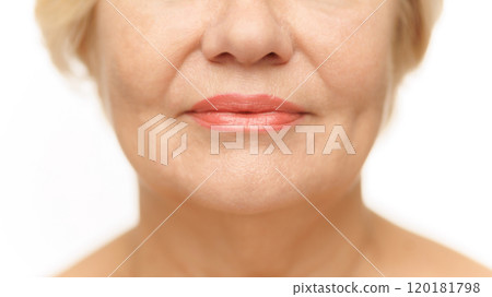 Cropped photo of mature female lips with lipstick against white studio background. Plump, moisturized lips. Mimicable wrinkles. 120181798