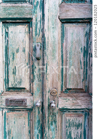 An old front damaged door, green painting is peeling on the wood An old front damaged door, green painting is peeling on the wood 120182025