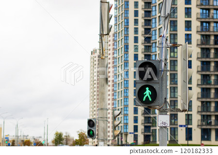 There is a pedestrian crossing sign positioned next to a traffic light There is a pedestrian crossing sign positioned next to a traffic light 120182333