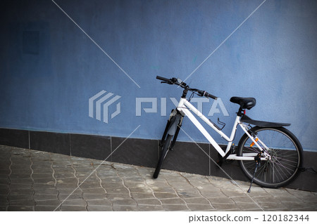 A Stylish Bicycle Positioned Against a Bright Blue Wall Within a Vibrant Urban Setting 120182344