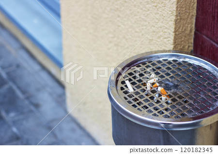 An ashtray made of stainless steel that contains some cigarettes 120182345