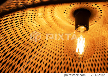 This is a close up view of a light bulb that is hanging from the ceiling 120182484