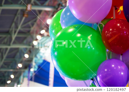 A large bunch of colorful balloons is beautifully hanging from the ceiling 120182497