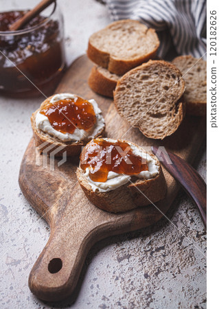 Onion jam on toast with cream cheese, gray background. 120182626