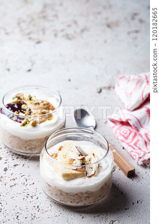 Overnight oatmeal with peanut butter, banana, nuts and jam in jars. Overnight oatmeal with peanut butter, banana, nuts and jam in jars. 120182665