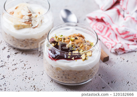 Overnight oatmeal with peanut butter, banana, nuts and jam in jars. Overnight oatmeal with peanut butter, banana, nuts and jam in jars. 120182666