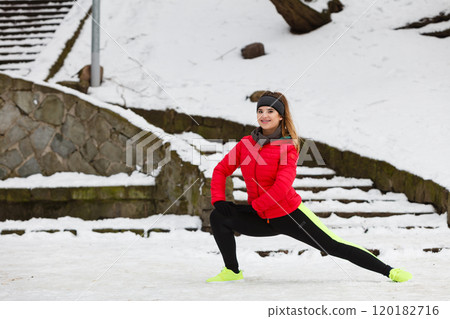 Woman exercising legs outside during winter 120182716