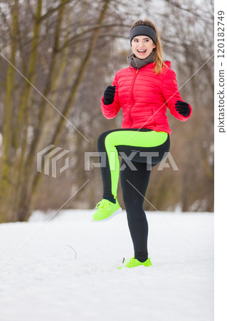 Woman wearing sportswear exercising outside during winter 120182749