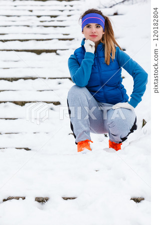 Woman wearing warm sportswear relaxing after exercising 120182804