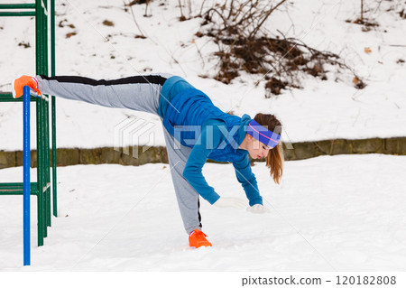Woman wearing sportswear urban exercising outside during winter 120182808