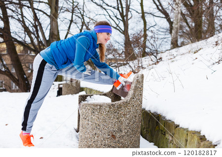 Woman wearing sportswear exercising outside during winter Woman wearing sportswear exercising outside during winter 120182817