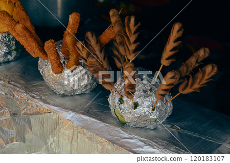 Deep fried cheese sticks and sausage sekuwa or skewers mounted on a pomelo fruit wrapped in tin foil, authentic local traditional nepali street food in Pokhara Nepal 120183107