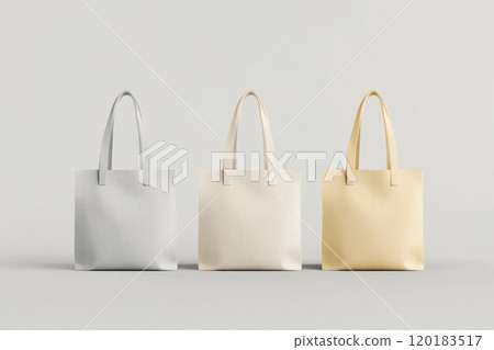 Three canvas tote bags in gray, cream, and yellow showcase space for custom text or logos in a clean environment. Three canvas tote bags in gray, cream, and yellow showcase space for custom text or logos in a clean environment. 120183517