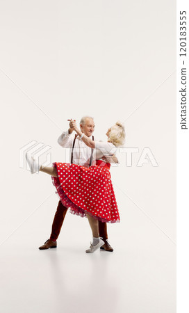 Senior man and woman engage in lively dance, dressed in vintage-inspired clothing isolated on white background Senior man and woman engage in lively dance, dressed in vintage-inspired clothing isolated on white background 120183555
