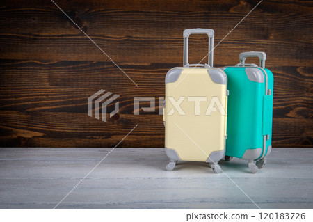 Miniature travel suitcases on a light and dark wooden background 120183726