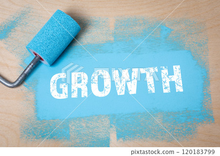 GROWTH. Blue color and paint roller on a wooden background GROWTH. Blue color and paint roller on a wooden background 120183799