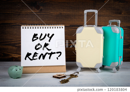 Buy or Rent concept. Travel suitcases, house keys on a wooden background Buy or Rent concept. Travel suitcases, house keys on a wooden background 120183804