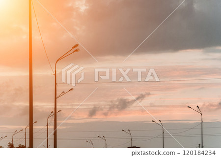 Sunset sky with a few clouds and a street lights silhouette Sunset sky with a few clouds and a street lights silhouette 120184234