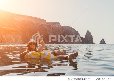 Woman, Santorini, Float Woman floats on inflatable ring in Santorini's ocean. Woman, Santorini, Float Woman floats on inflatable ring in Santorini's ocean. 120184252