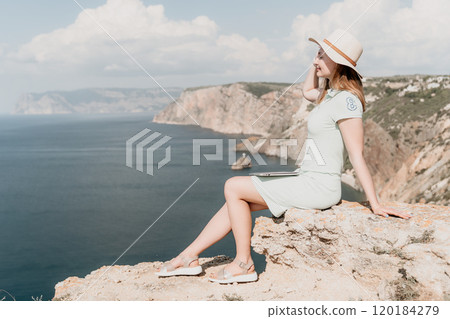 Young Woman Relaxing on a Clifftop with a Laptop Young Woman Relaxing on a Clifftop with a Laptop 120184279