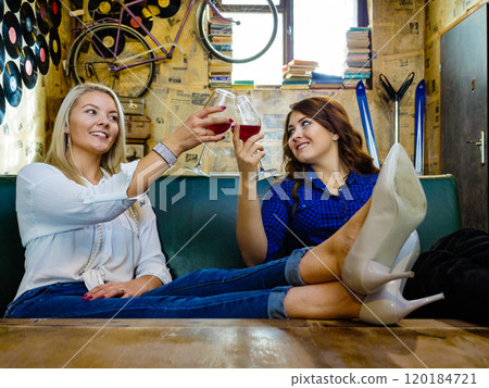 Girls in pub club gossiping and talking 120184721