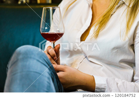 Woman in white shirt holding glass of wine 120184752