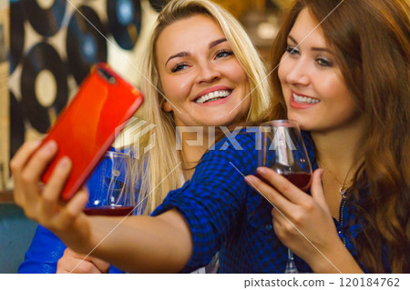 Girls in pub club taking self photo with phone Girls in pub club taking self photo with phone 120184762