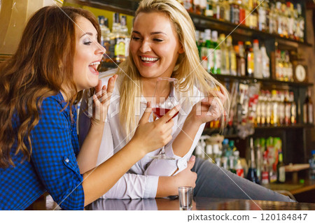 Girls in pub club gossiping and talking 120184847